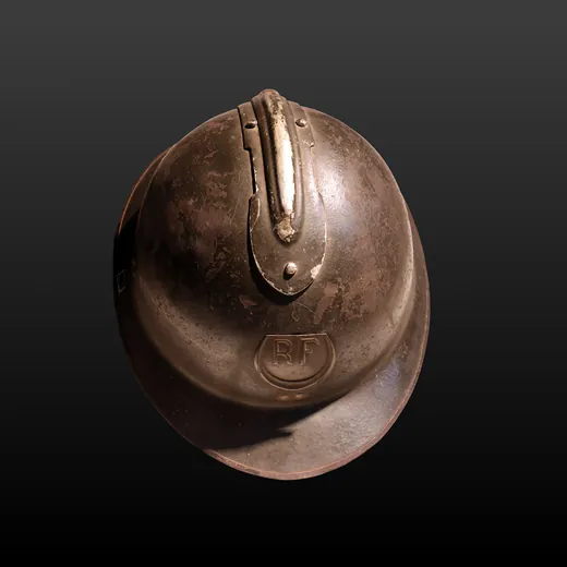 Casque Adrian modèle 1915 de teinte moutarde exposé en vitrine de musée