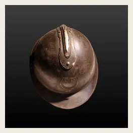 Casque Adrian modèle 1915 de teinte moutarde exposé en vitrine de musée