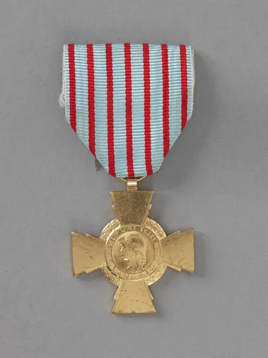 Avers d'une croix du combattant en bronze : effigie de la République casquée, légende RÉPUBLIQUE FRANÇAISE, couronne de laurier entre les branches, ruban bleu horizon à sept raies rouges