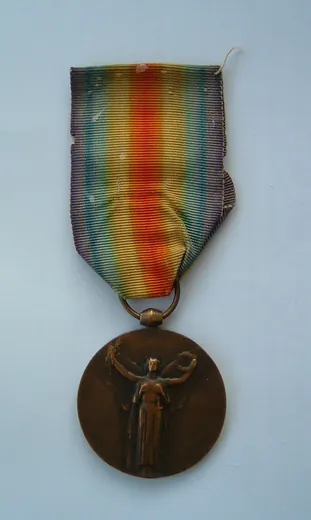Médaille interalliée de la Victoire, modèle français : Victoire ailée de face sur son ruban arc-en-ciel