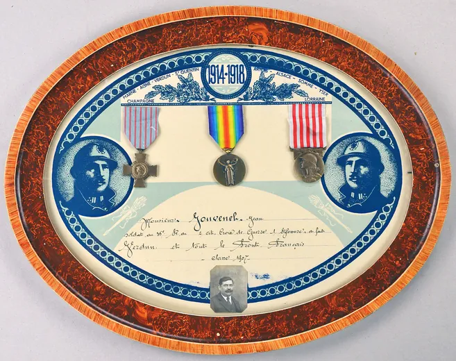 Cadre souvenir ovale de Jean Jouvenel, classe 1907, avec sa photographie, la croix du combattant, la médaille interalliée et la médaille commémorative de la Grande Guerre