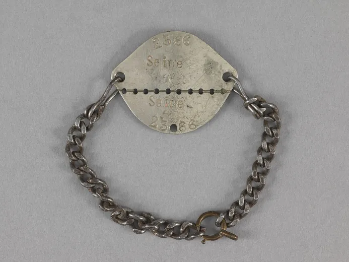 Plaque d'identité modèle 1918 de Gustave Pommier avec son bracelet de chaîne, sécable, portant « 2366 Seine 4 » répété de part et d'autre de la ligne de trous