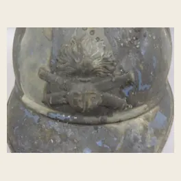 Gros plan de l'attribut de l'artillerie sur un casque Adrian de la Grande Guerre